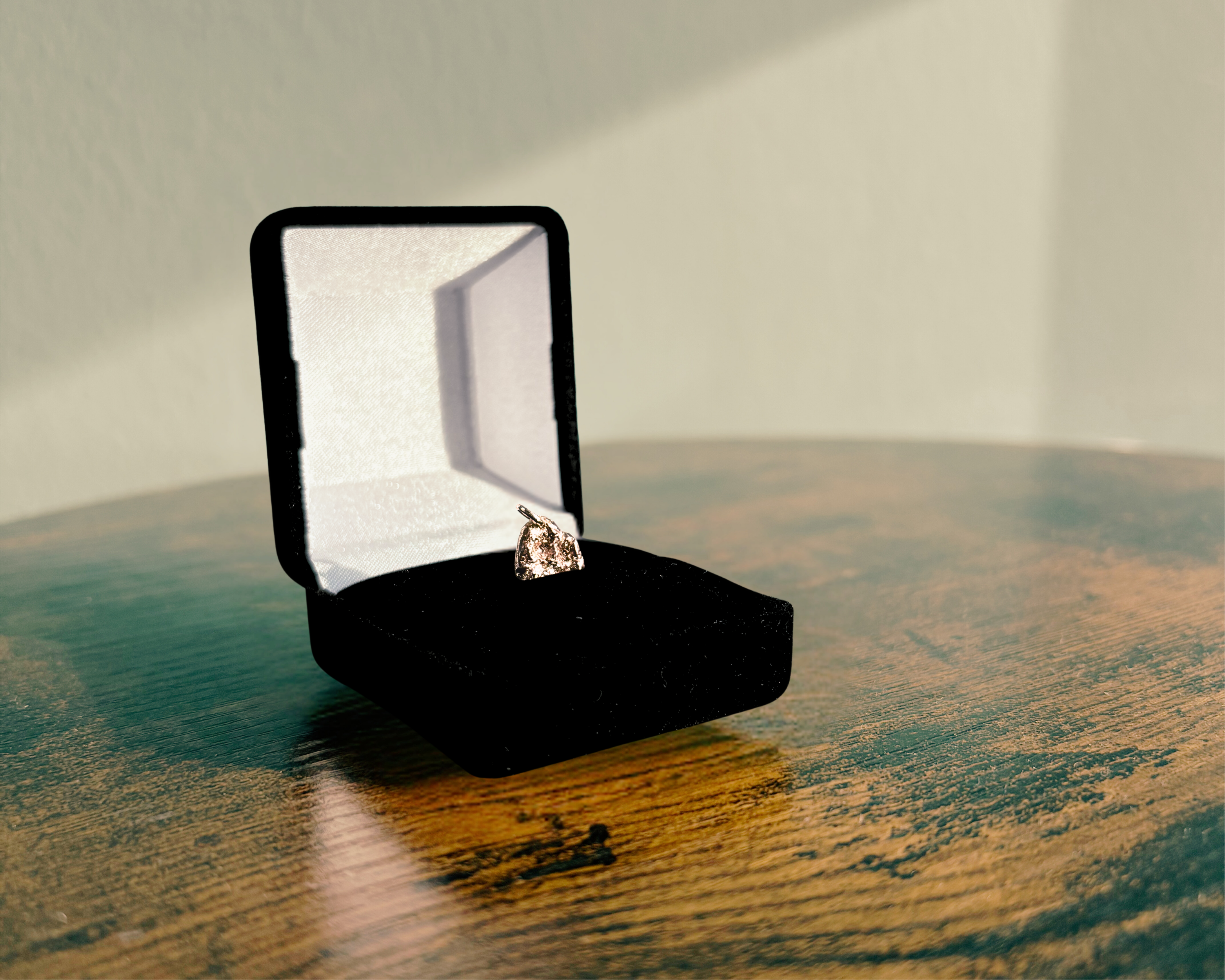 Re-Loved Liminoko Nugget-Anhänger aus recyceltem Edelmetall, luxuriös und einzigartig handgefertigt, präsentiert in schwarzer Schmuckbox auf Holztisch.